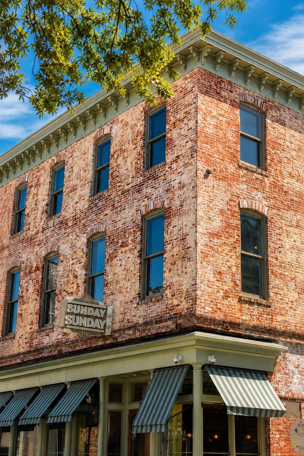 Corner view of the historic Keystone brick building and upper windows on a quiet Savannah street